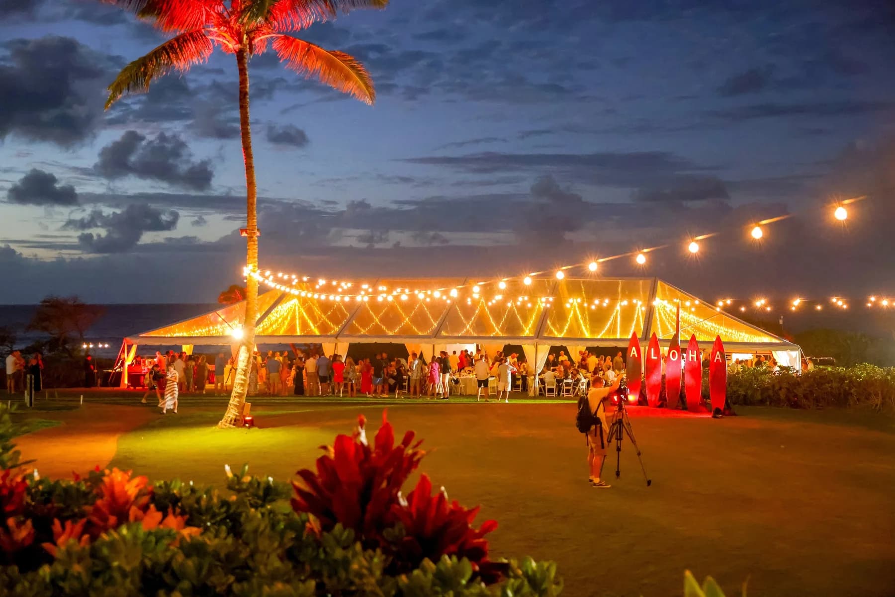 Large illuminated tent event setup at dusk